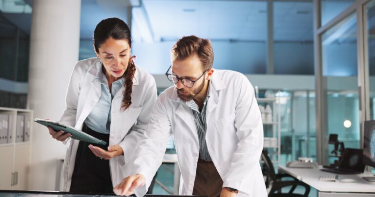 Two clinical research professionals reviewing study plans in a modern research facility, representing early-phase clinical trial planning in Germany.